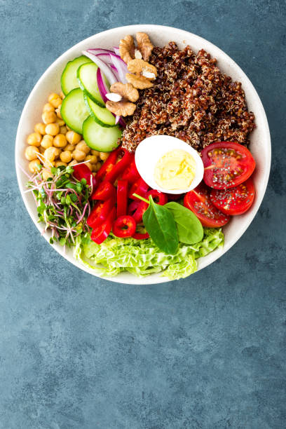 istock Buddha bowl dish with boiled egg, chickpea, fresh tomato, sweet pepper, cucumber, savoy cabbage, red onion, green sprouts, spinach leaves, chia and quinoa 947540216