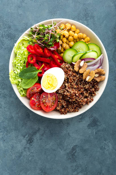istock Buddha bowl dish with boiled egg, chickpea, fresh tomato, sweet pepper, cucumber, savoy cabbage, red onion, green sprouts, spinach leaves, chia and quinoa 947540290