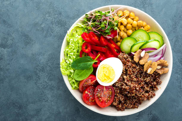 istock Buddha bowl dish with boiled egg, chickpea, fresh tomato, sweet pepper, cucumber, savoy cabbage, red onion, green sprouts, spinach leaves, chia and quinoa 947540334