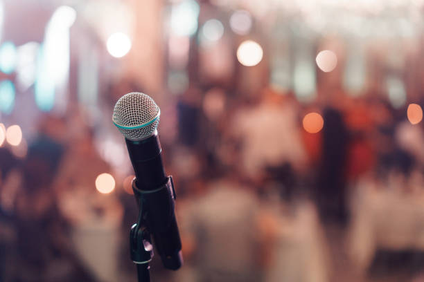 istock Close up microphone on stage in concert hall restaurant or conference room. Blurred background. Copy space 947540546