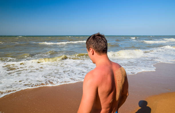 Athletic man on the beach. A man goes into the sea water.
