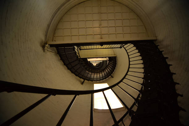 istock Vertical view of black spiral staircase in white lighthouse 947541718