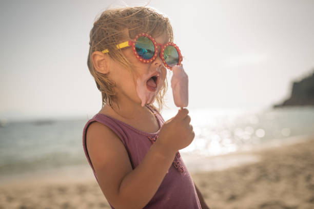 Cool little girl with icecream on summer holiday Cool little girl with icecream on summer holiday cone shape photos stock pictures, royalty-free photos & images