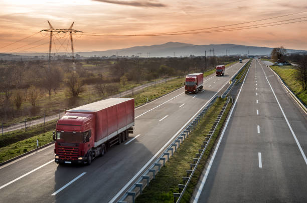 istock Caravan of Red Lorry trucks on highway 947552128