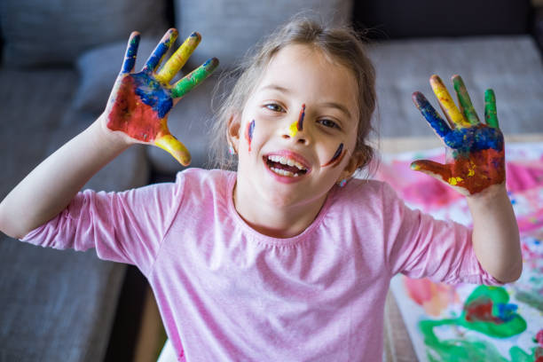 istock Portrait cute girl with colored hands 947552266