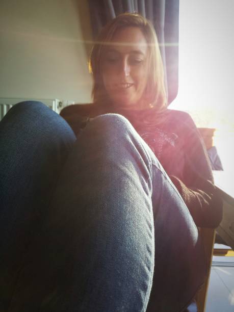istock woman reading in a sofa wight bright sunlight pouring in 947559762
