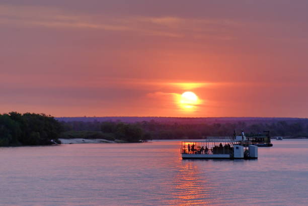 bateaux pontons sur le fleuve zambèze au coucher du soleil - zambeze photos et images de collection