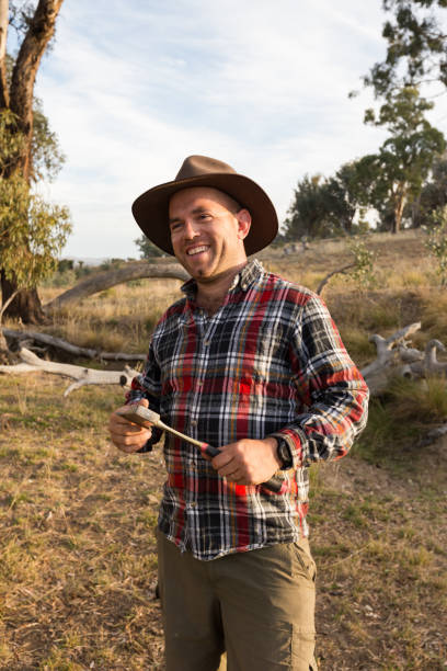 istock Happy farmer with axe in hand smiles towards camera 947577172