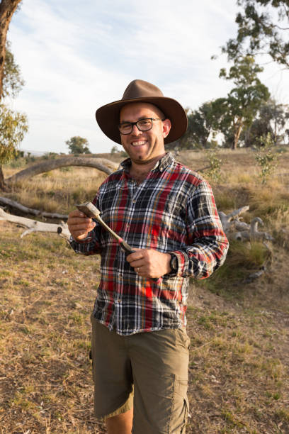 istock Happy farmer with axe in hand smiles towards camera 947577210