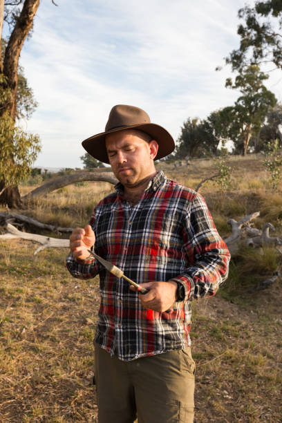 istock A man in red flannel and cowboy hat inspects his axe in afternoon light 947577222