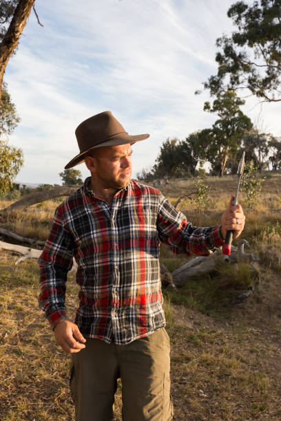 istock Rustic country boy inspects his axe in the afternoon light 947577252