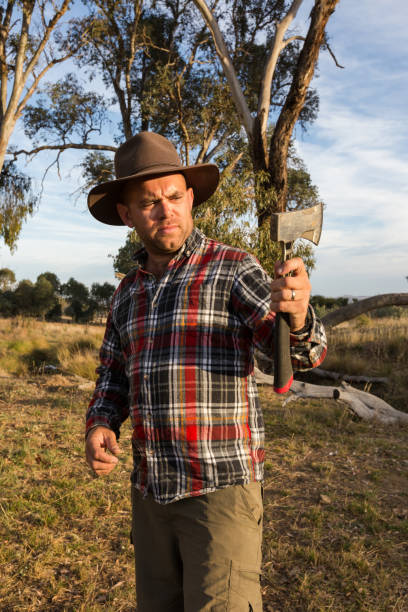 istock Rustic country boy inspects his axe in the afternoon light 947577280