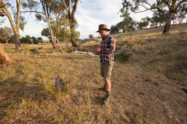 istock A man in red flannel and cowboy hat inspects his axe in afternoon light 947577472