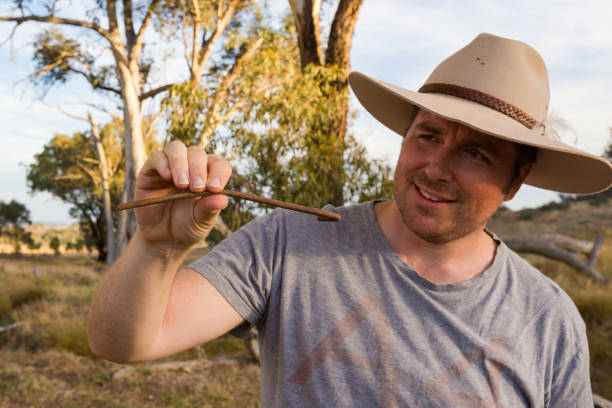 istock Man in cowboy hat inspects a bent rusty tent peg 947581004