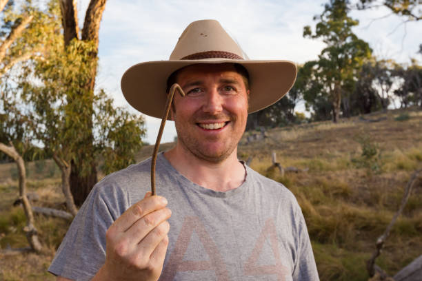 istock Man in cowboy hat inspects a bent rusty tent peg 947581024