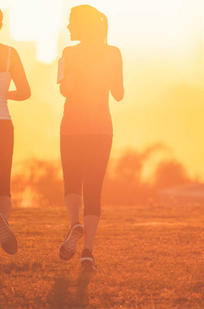 istock Two women running together in the park. 947584934