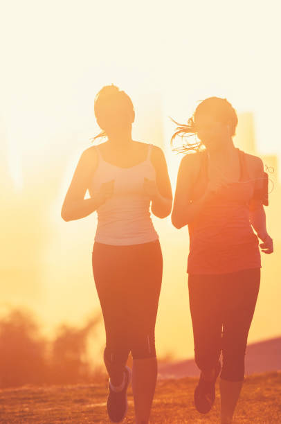 istock Two women running together in the park. 947584972