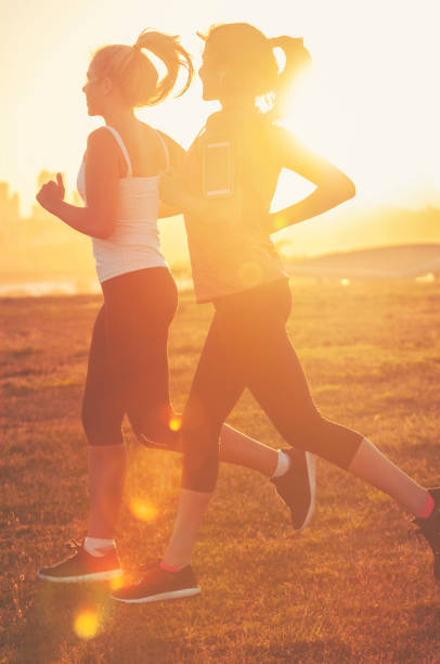 istock Two women running together in the park. 947584988