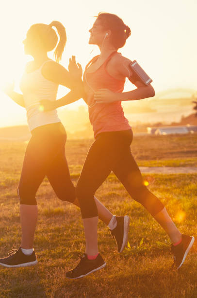 istock Two women running together in the park. 947585010