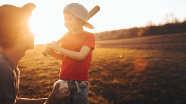 padre e figlio si preparano per una partita di baseball - baseball player baseball men softball foto e immagini stock