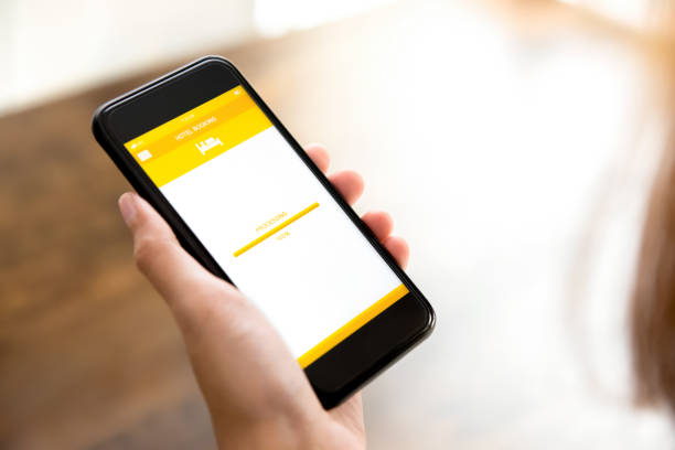 istock Woman hand holding smartphone showing processing page of hotel booking application 947648852