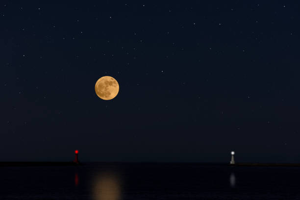 istock Full moon rising over the sea and the lighthouse 947649512
