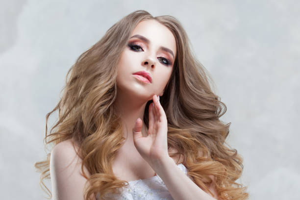 istock Young beautiful bride with luxurious curls. Wedding hairstyle with tiara. 947651946