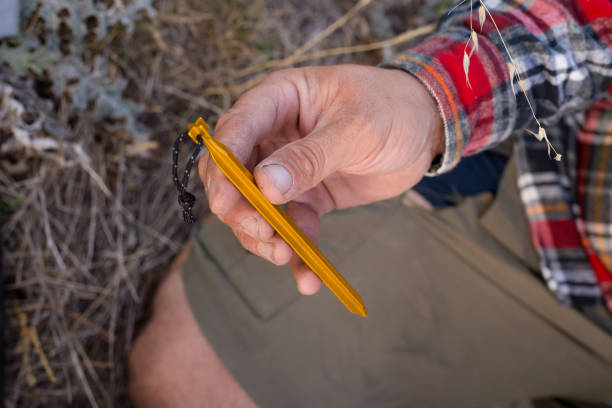 istock A man with rough hands holds and inspects his modern tent peg 947655666
