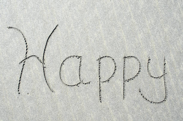 istock Happy etched out into ocean beach sand 947656458