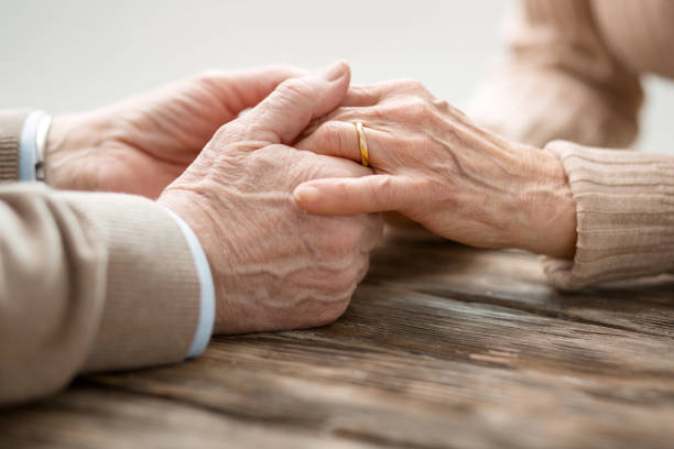 Aged married couple holding hands stock photo