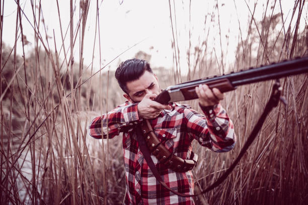 istock Young Bearded Hunter Shooting With Rifle 947660858