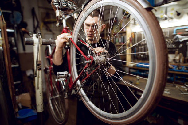 istock Professional young man cleaning bicycle rear bar in the workshop. 947664462