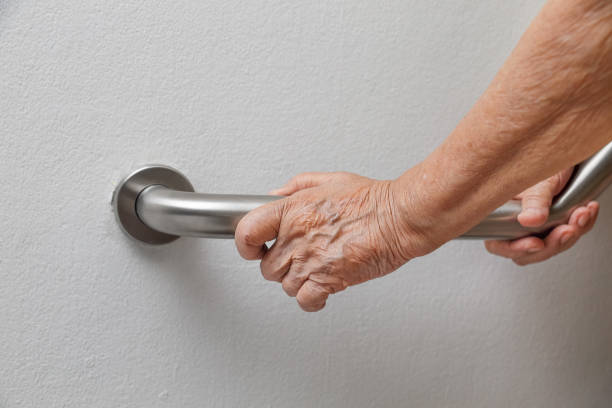 Elderly woman holding on handrail for safety walk steps Elderly woman holding on handrail for safety walk steps burglar bars stock pictures, royalty-free photos & images