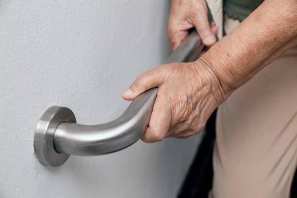 istock Elderly woman holding on handrail for safety walk steps 947667944
