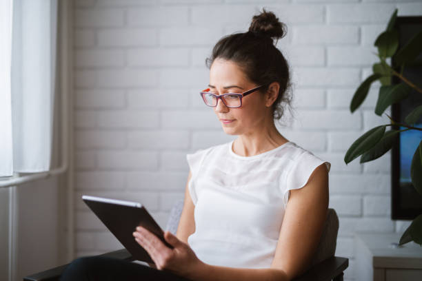 istock Middle aged attractive woman looking at tablet searching online. 947668652