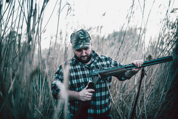 istock Hunter Putting Bullets in his Gun and Preparing for Hunting 947673882