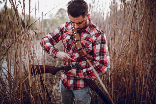 istock Hunter Putting Bullets in his Gun and Preparing for Hunting 947676148