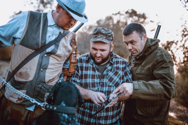 istock Group of Hunters Looking for GPS Coordinates on Tablet in Nature 947683344
