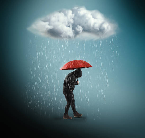 istock Woman with an umbrella under a rainy cloud 947690960
