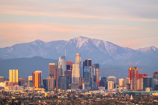 Downtown Los Angeles skyline at sunset with snowcapped Mt Baldy and San Gabriel Mountains behind