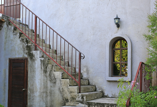 Outside vintage stair with metal railing. Construction is grunge and rusty touching.