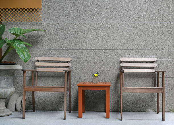 istock Wood chairs with mini wood table against rug cement wall. 947708998