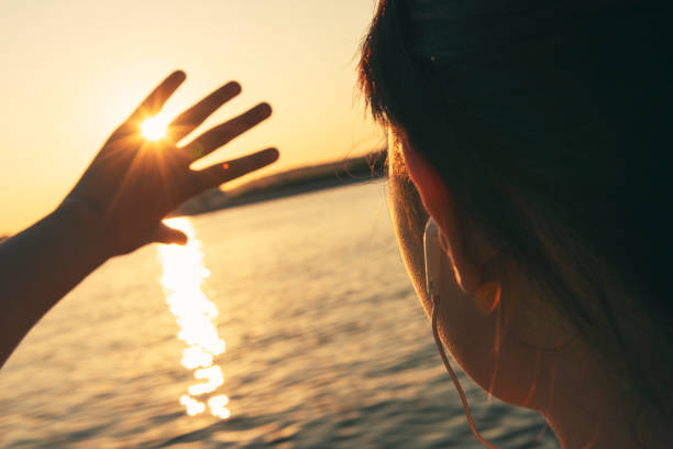 istock Girl looks at the sun through her hand 947710298