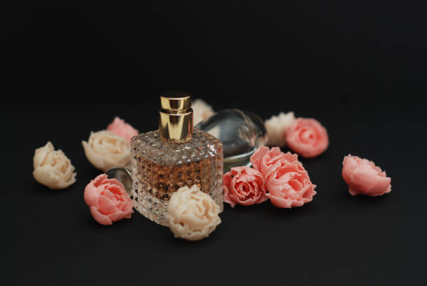 istock Bottle Perfume and Fake Roses on dark Black Background with copy Space Text 947713860