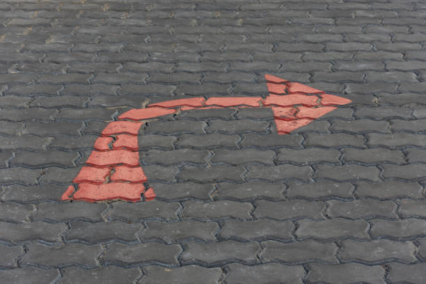 Arrow red sign paint on a brick road or walkway for turn right symbol