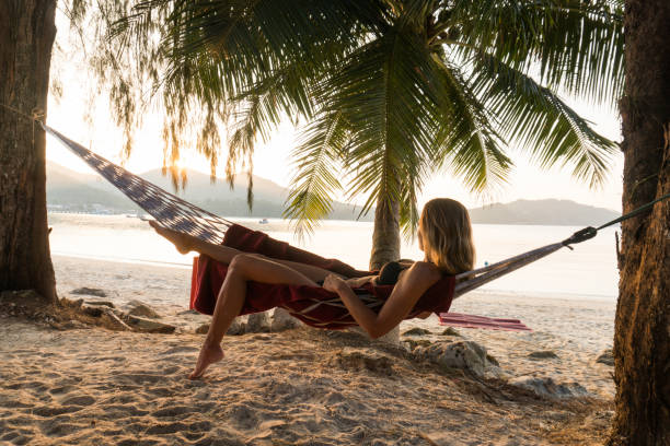 istock Relaxed woman spending a summer day in hammock at the beach. 947717822