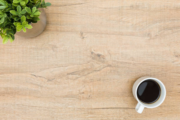 istock Minimal wood table with coffee and a small plant. Top view with copy space, flat lay. 947721404