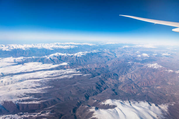 istock Wing of an airplane flying above the clouds with blue sky. 947721514