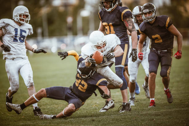istock Determined American football player passing through defense for a touchdown. 947721546