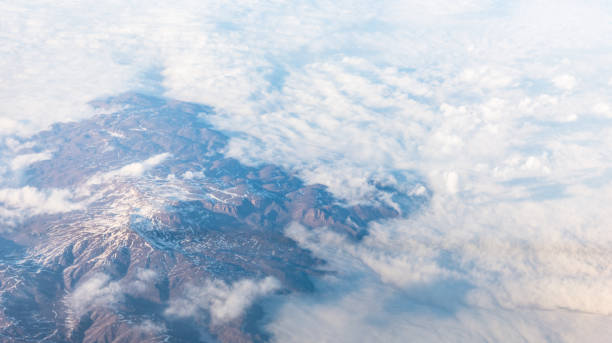 istock Wing of an airplane flying above the clouds with blue sky. 947721576